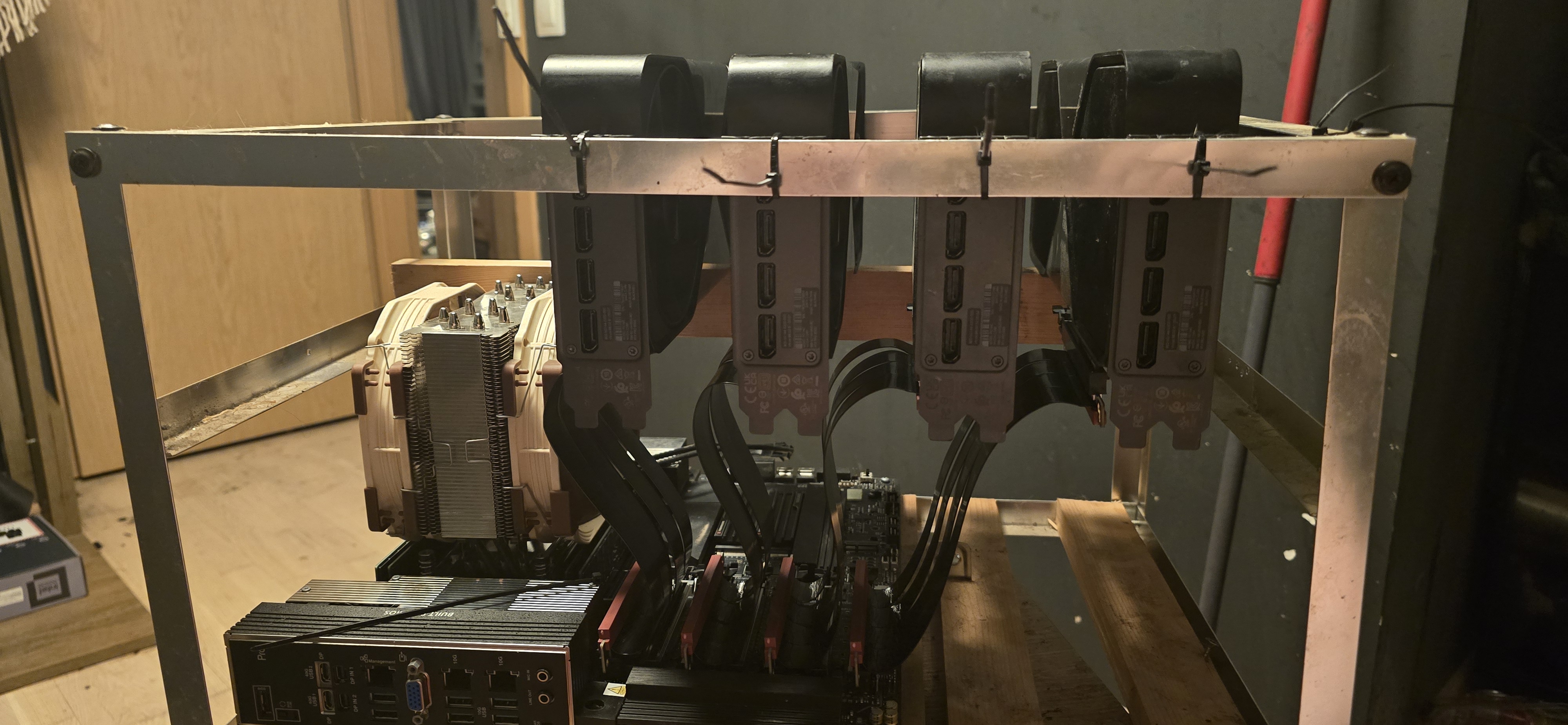 Front view of the rig: four cards with DisplayPort outputs, riser cables threaded down to the motherboard, ASUS Pro WS WRX90E-SAGE SE board with dual 10G ports below.